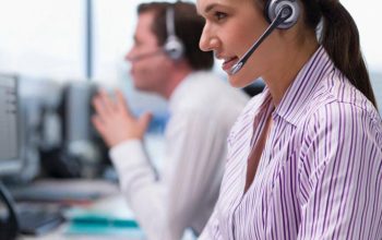 Business technical support specialist typing at a workstation in a Dubai office